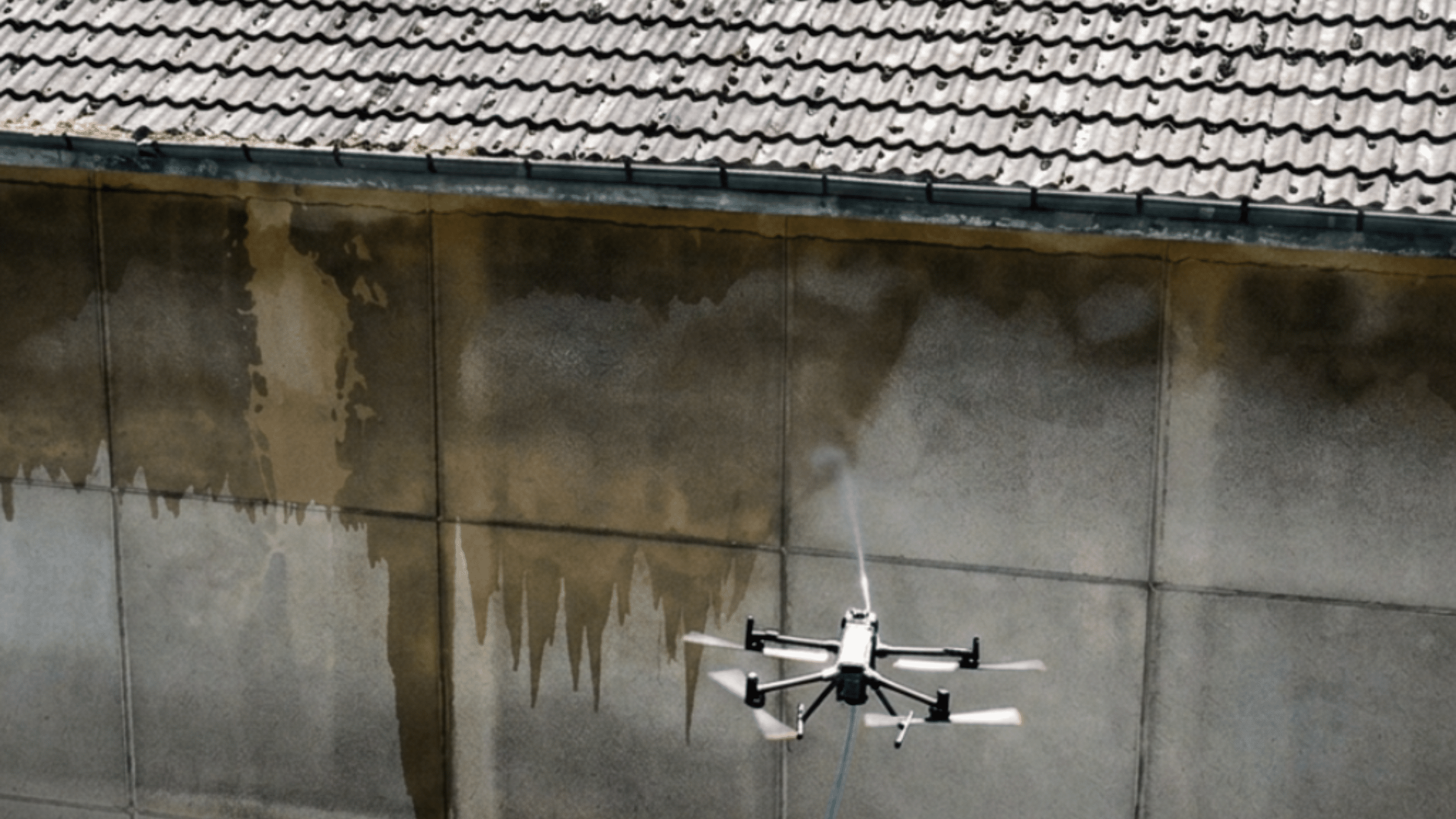Nettoyage d'une façade en béton industriel par un drone DJI Matrice opéré par Drones Nettoyage sur le site d'une laiterie Entremont (Groupe Sodiaal).